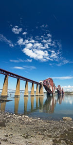 Bridge over sea against blue sky