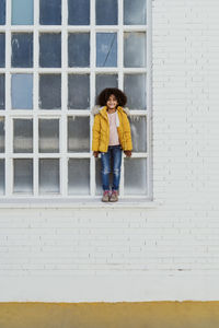 Portrait of girl standing on window sill