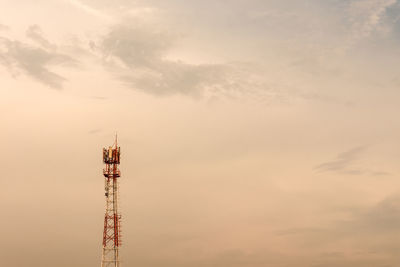 Communications tower against sky during sunset