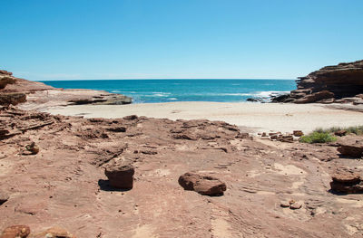 Scenic view of beach against clear blue sky