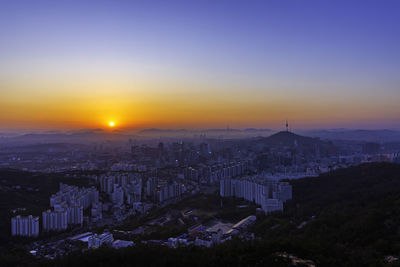 High angle view of buildings in city during sunset