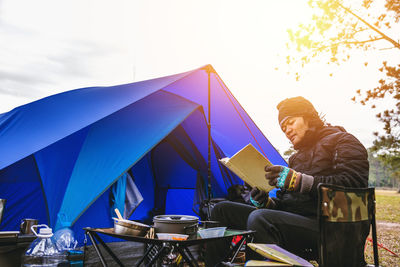 Man sitting on chair at campsite