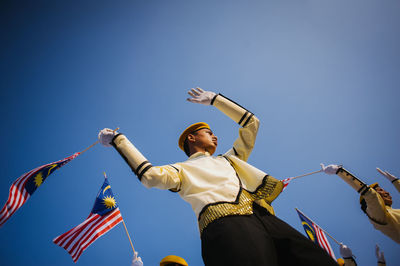 Low angle view of woman standing against sky