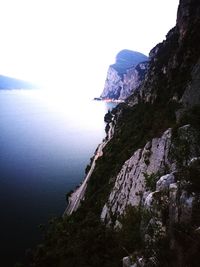 Scenic view of sea and mountains against clear sky