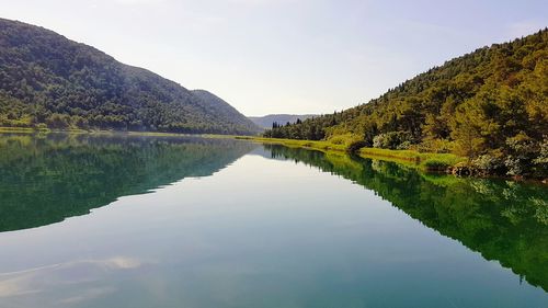 Scenic view of lake and mountains against sky