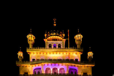 Low angle view of illuminated building against sky at night