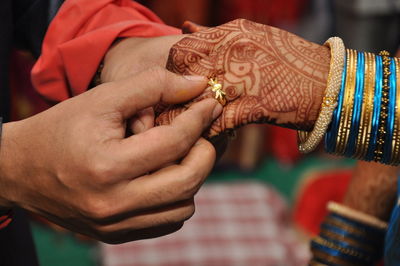 Cropped image of bridegroom inserting wedding ring in bride finger