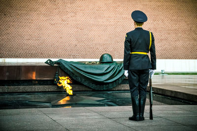 Rear view of man standing against wall