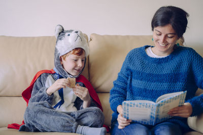 Mother and son sitting on sofa