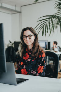 Portrait of young woman using laptop