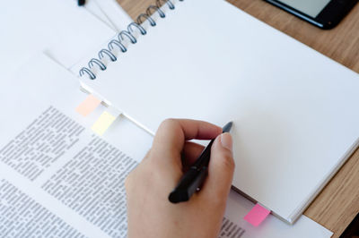 Low section of person reading book on table
