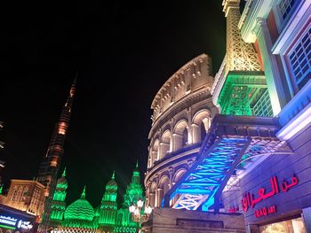 Low angle view of illuminated buildings in city at night