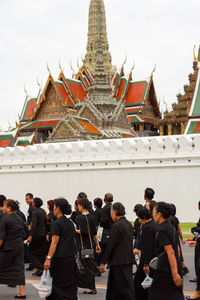 People at temple against sky