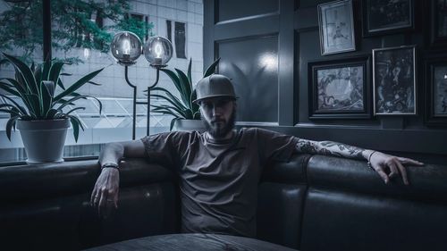Portrait of young man sitting on sofa at home
