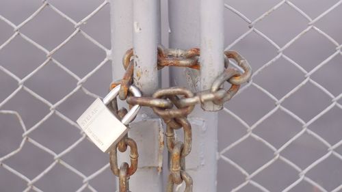 Close-up of padlock on metal fence