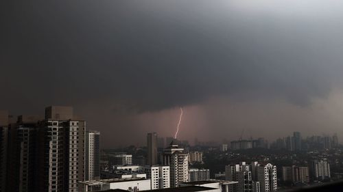 Panoramic view of buildings in city against sky at night