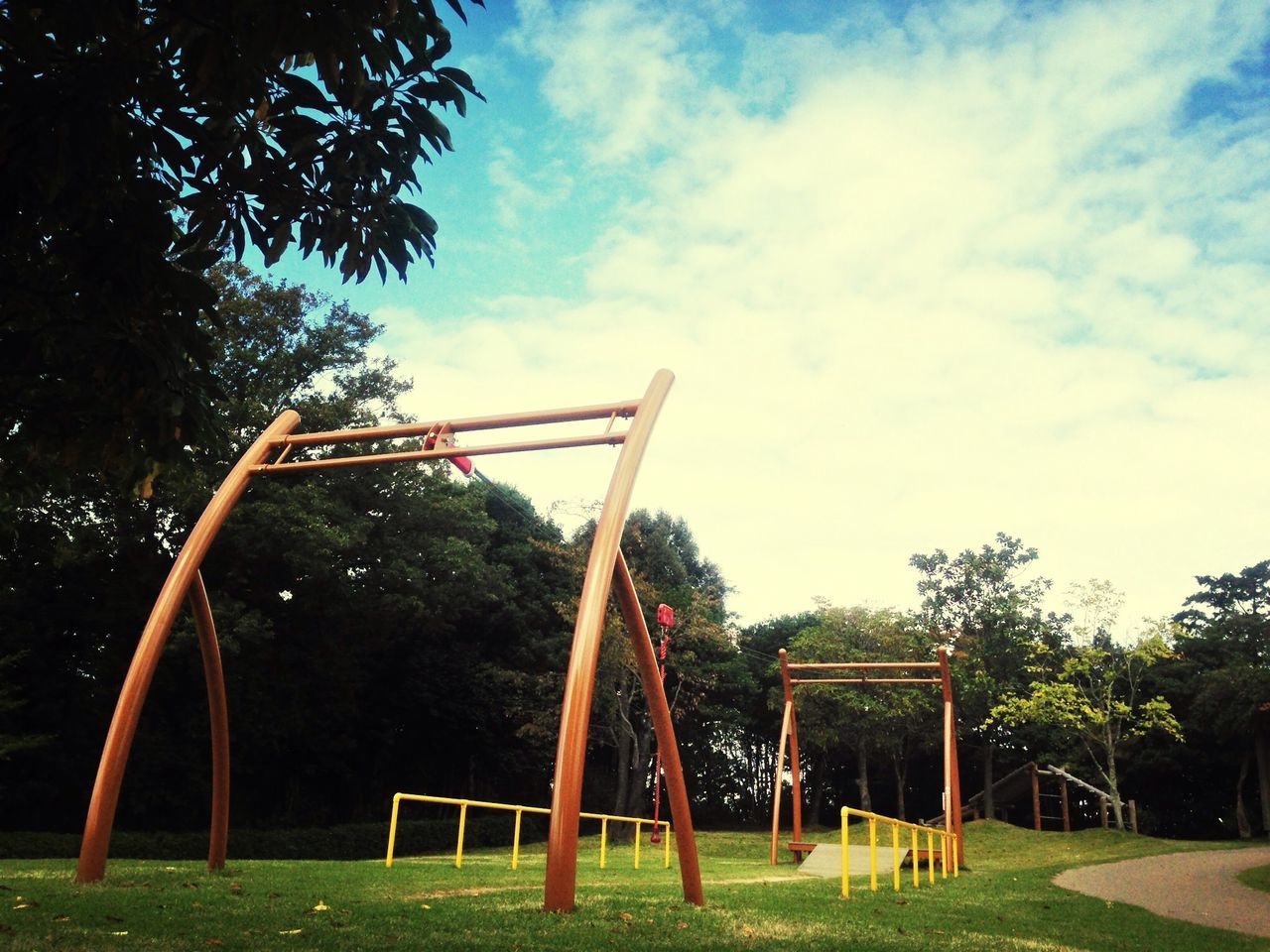 tree, sky, grass, park - man made space, sunlight, field, blue, absence, cloud, cloud - sky, playground, nature, day, outdoors, growth, tranquility, green color, empty, tree trunk, bench