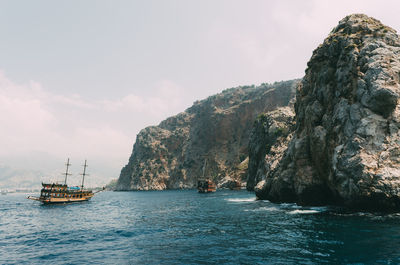 Scenic view of sea by cliff against sky