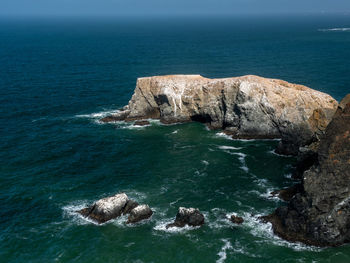 Scenic view of sea against rock formation