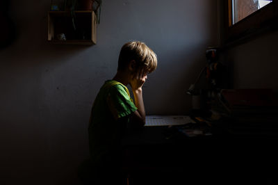 Side view of man using mobile phone at home
