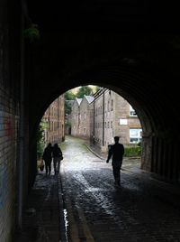 Rear view of people walking on footpath in rain
