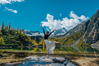 Man standing by lake against mountains