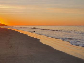 Scenic view of beach against sky during sunrise