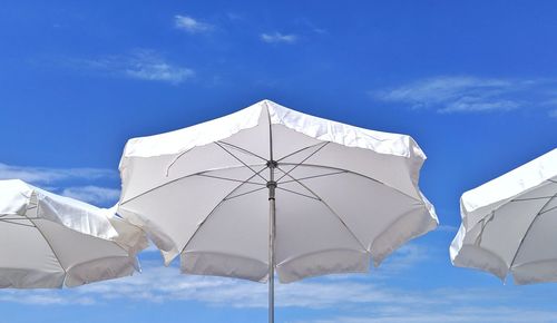 Low angle view of umbrella against blue sky