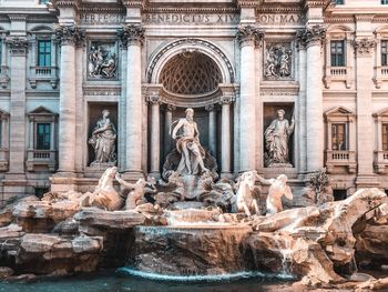 Statue of fountain in front of historical building