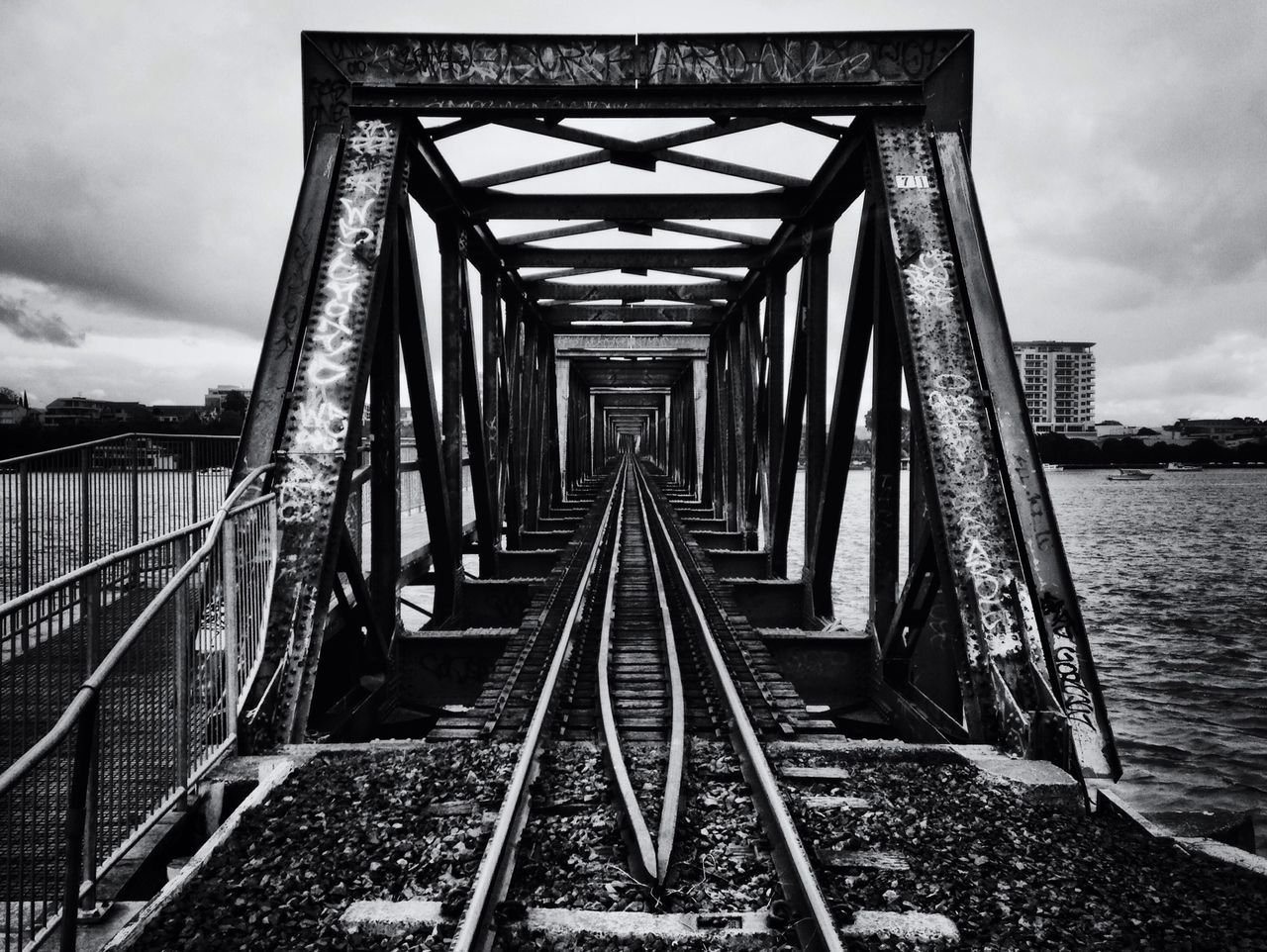 built structure, architecture, the way forward, sky, diminishing perspective, railing, connection, railroad track, cloud - sky, vanishing point, metal, bridge - man made structure, transportation, cloud, rail transportation, cloudy, long, day, footbridge, outdoors