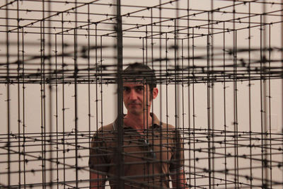 Portrait of man standing by fence