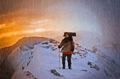 Full length of man standing on snow covered mountain