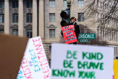 Woman with banner on stoplight during 2017 women march