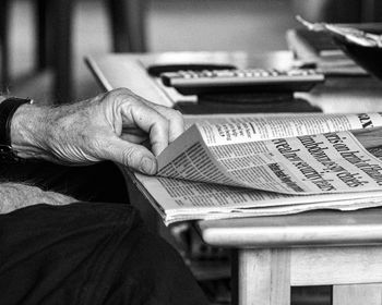 Cropped hand of man holding book