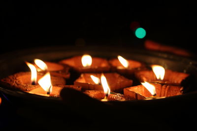 Close-up of lit candles in the dark