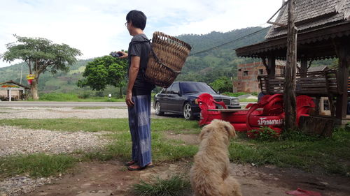 Man and dog on car against sky