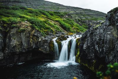 Scenic view of waterfall against sky