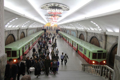 People walking on illuminated railroad station