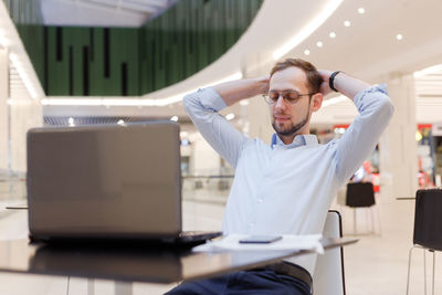 Businessman resting while sitting in mall