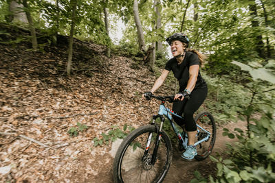 Woman mountain bikes through lincoln woods state park in rhode island