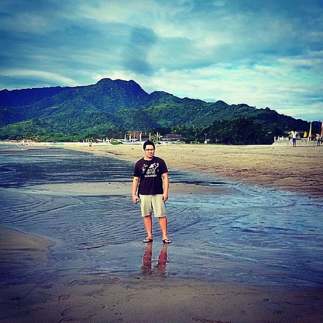 mountain, sky, beach, sand, lifestyles, leisure activity, water, mountain range, sea, full length, men, cloud - sky, rear view, shore, vacations, scenics, cloud, person