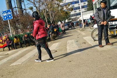 Woman standing on road in city