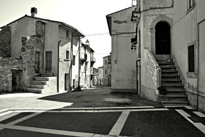 Alley amidst buildings in city against clear sky