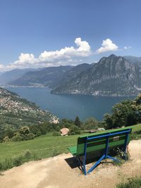 Empty bench on mountain against sky