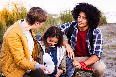 Portrait of smiling friends standing against trees