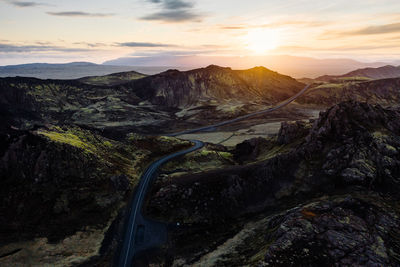 High angle view of road amidst mountains against sky during sunset