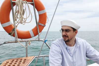 Man in boat on sea against sky