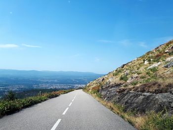 Road leading towards mountain against sky