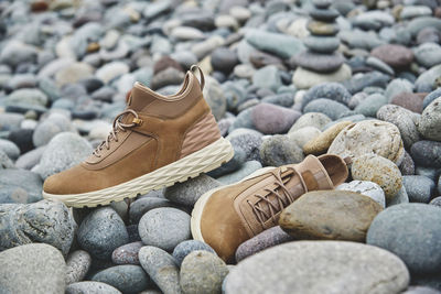 A pair of brown leather waterproof trekking boots on a sea coast. hiking concept.