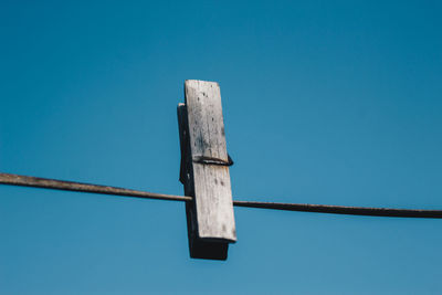 Low angle view of wood against clear blue sky